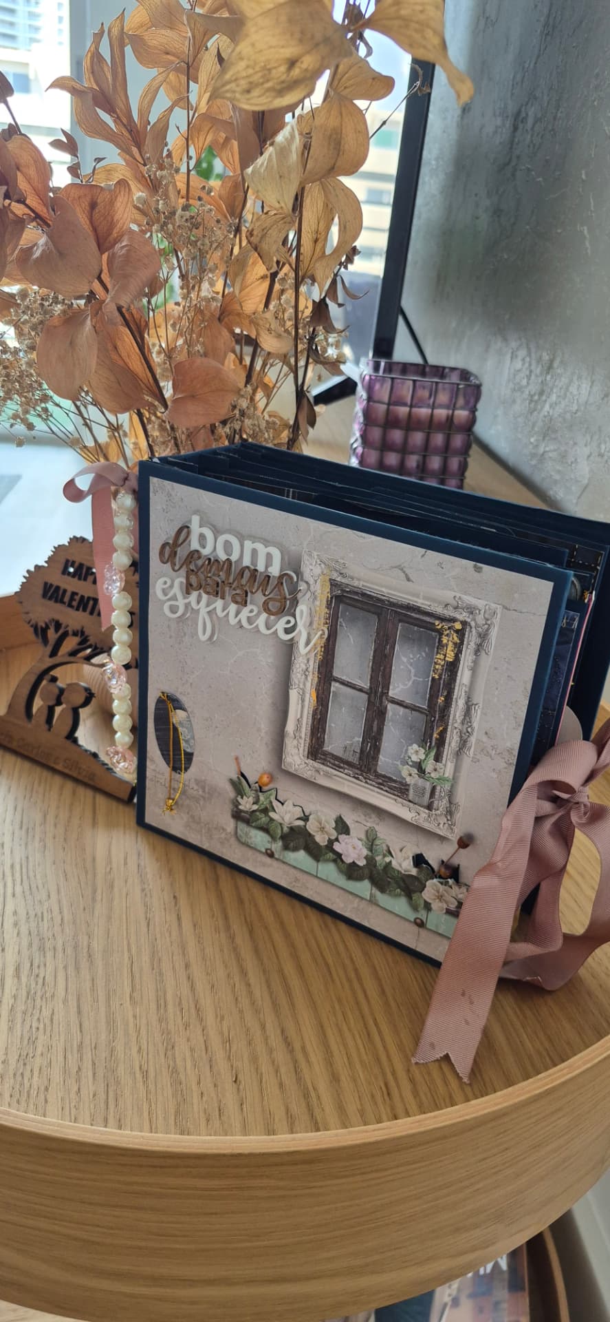 Capa de álbum de memórias com textura cinza, ilustração de janela antiga, flores brancas e o texto Bom demais para esquecer