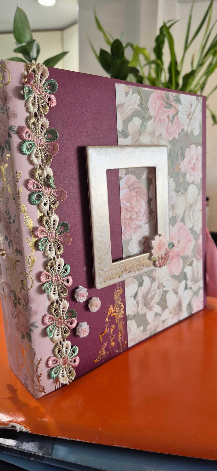 Capa de álbum de recortes decorada com rendas florais coloridas e moldura quadrada central de cor creme