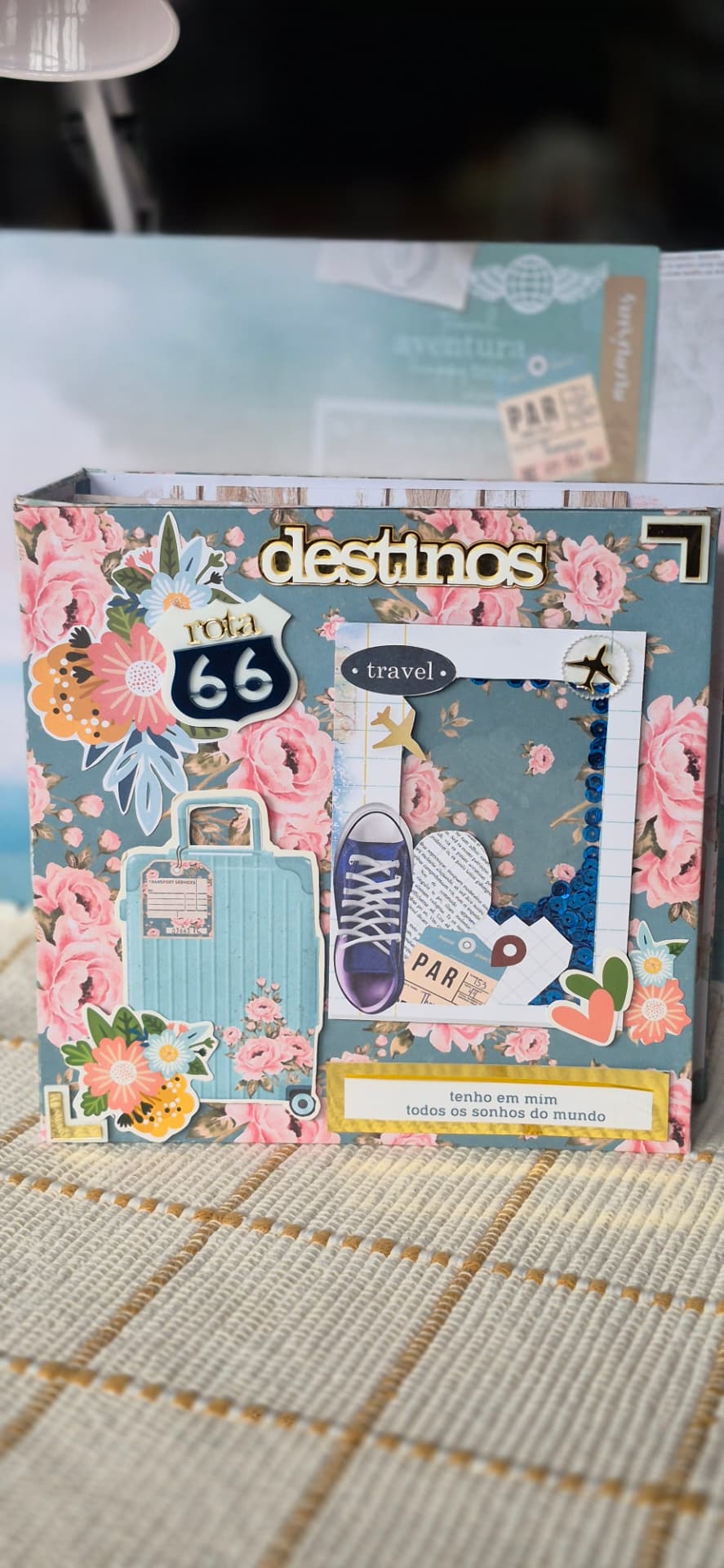 Capa de álbum de recortes decorada com elementos de viagem como malas e a Rota 66