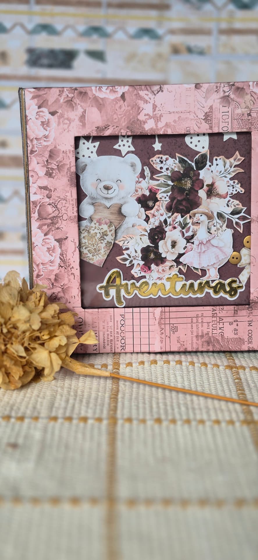 Capa de álbum com moldura floral rosa, ilustrações de urso e pato e a inscrição Aventuras