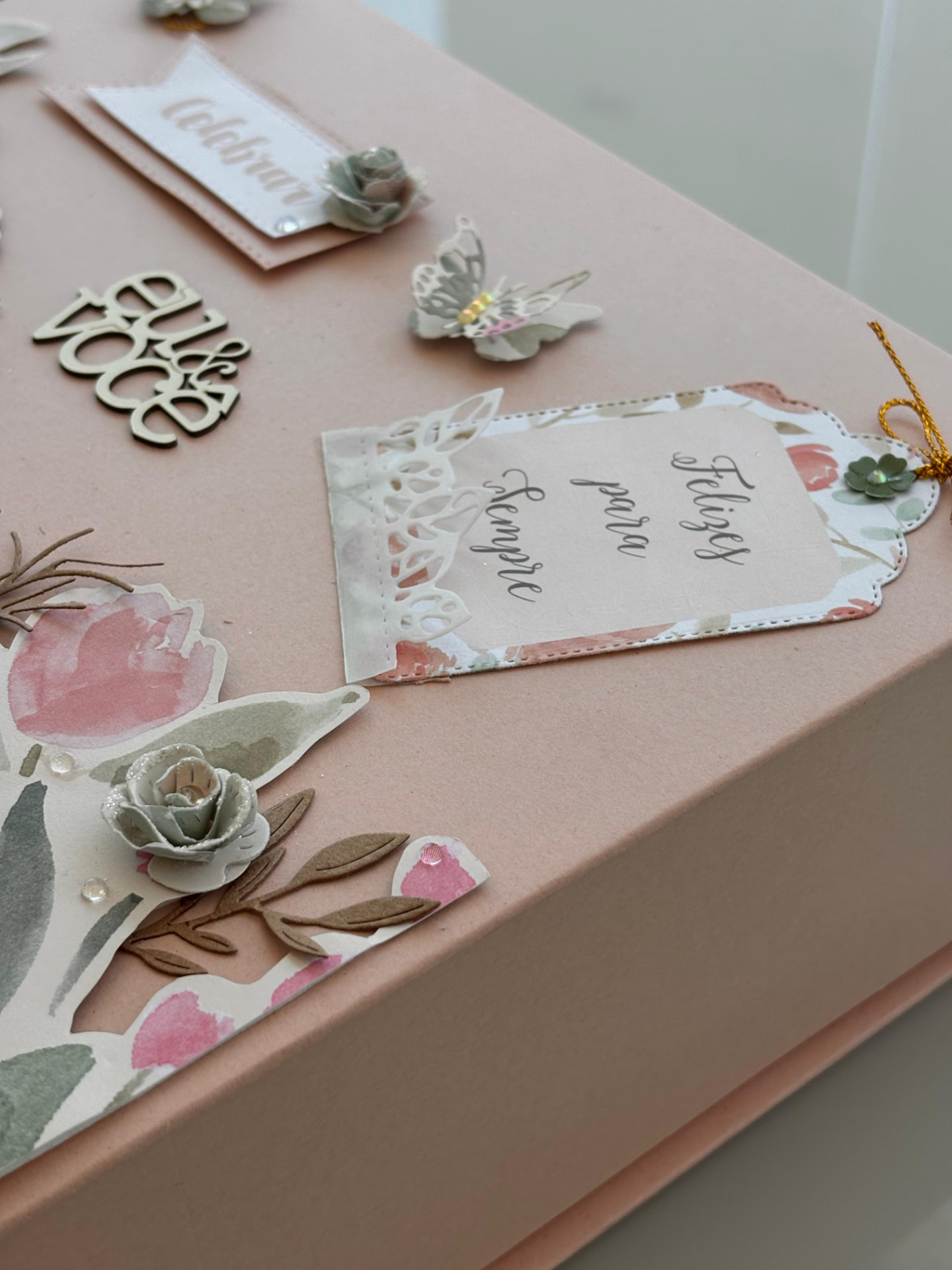 Tampa de caixa de presente decorada com flores de papel e etiqueta Felizes para sempre