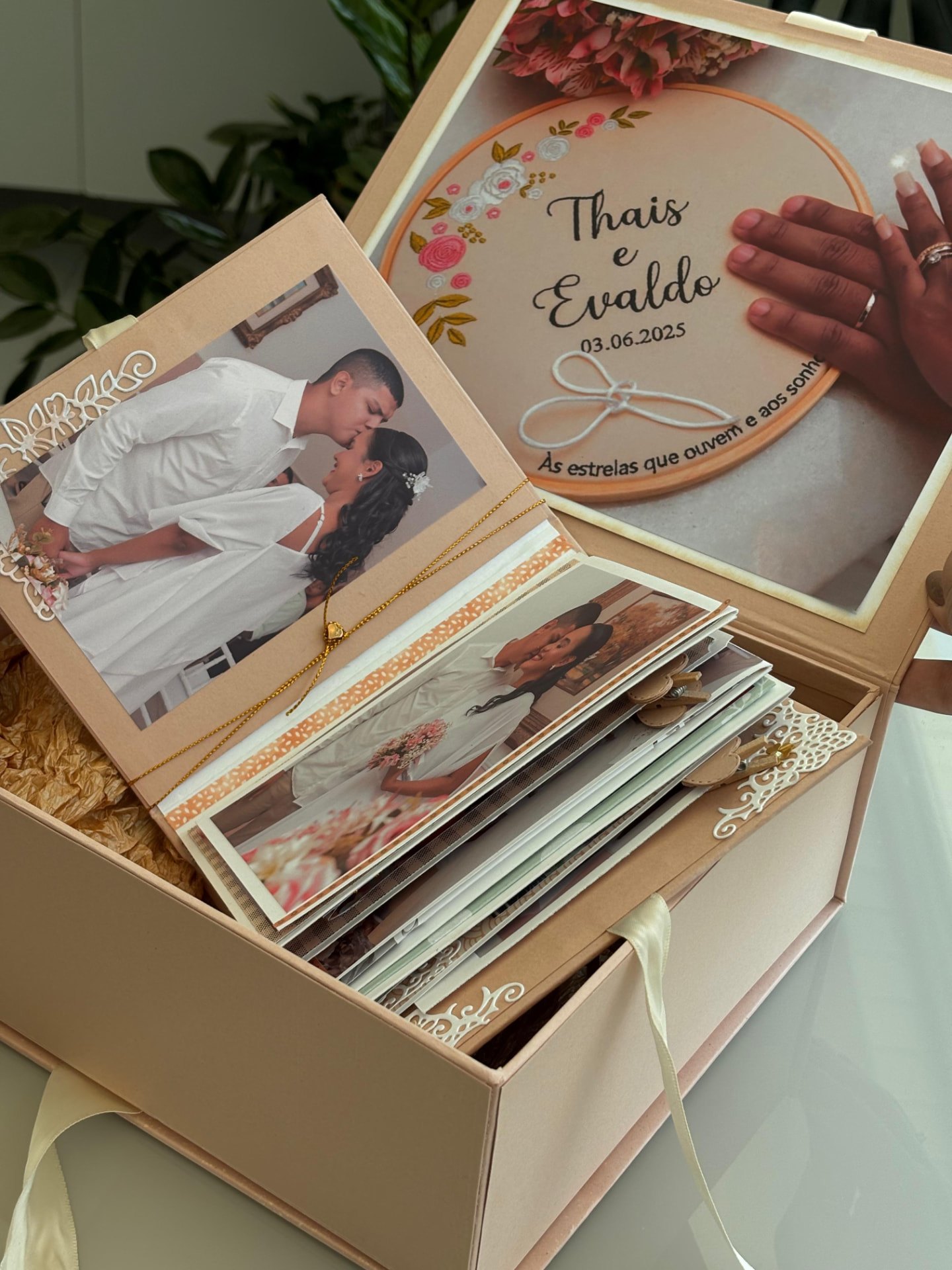 Caixa de presente aberta com álbum em camadas e imagem comemorativa na tampa