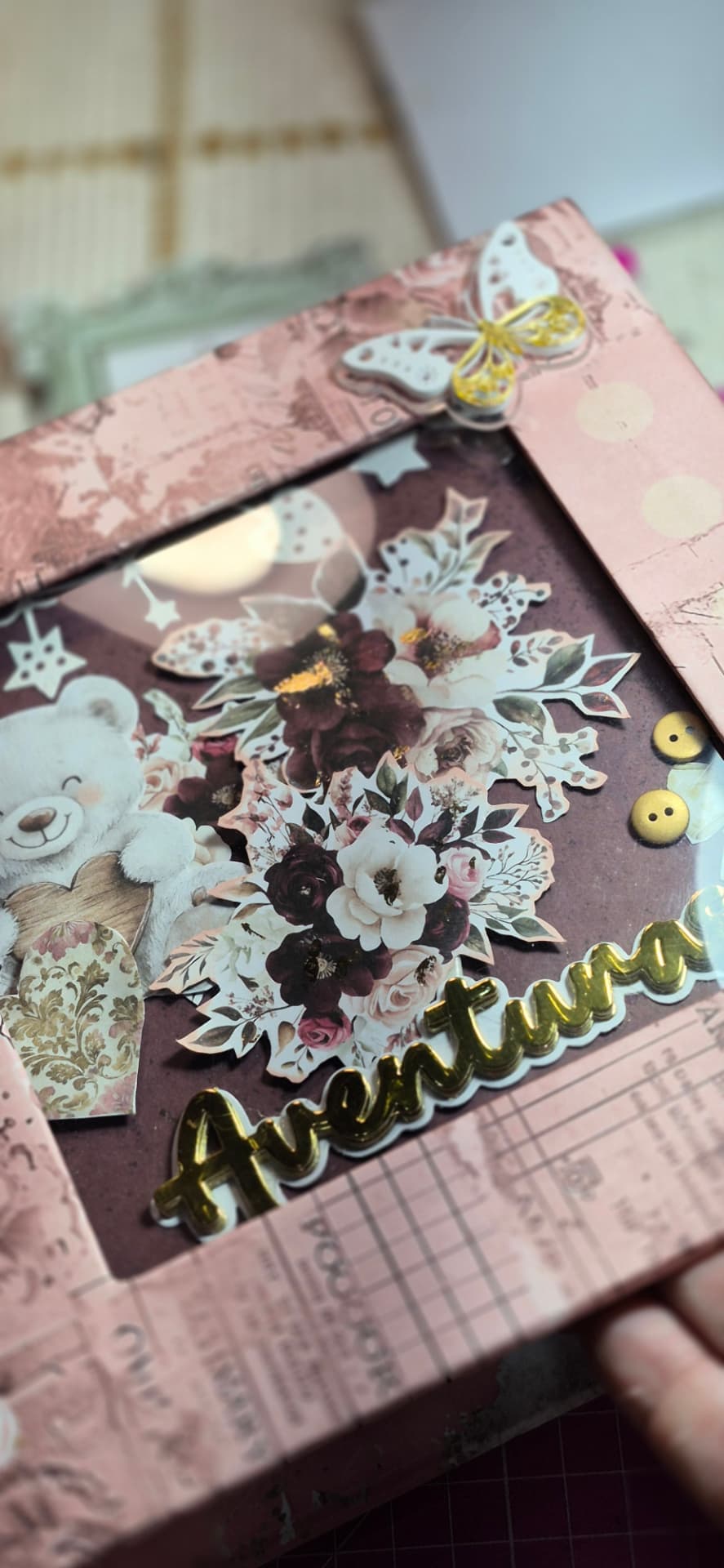 Página de scrapbook com moldura rosa, urso de pelúcia e a palavra dourada Aventuras